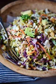 a wooden bowl filled with coleslaw and carrots