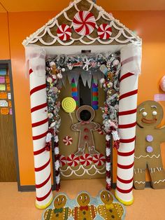 a gingerbread house decorated for christmas with candy canes and candies on the door