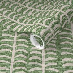 a green and white wallpaper with an abstract design on the top half of it