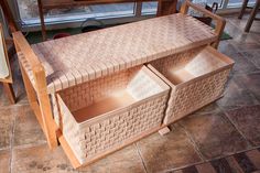 a wooden bench with two baskets on it and a window in the backround