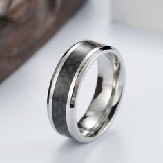 Titanium steel wedding band provides several unique factors that make it the good metal for jewelry. Titanium steel ring is very strong, more dent, bend and scratch resistant than other precious metals, is really lightweight and importantly keeps the modern look color forever.Weight: 7.2 gWidth: 8 mmMaterial: Titanium SteelPlating Color: Silver Modern Silver Tungsten Carbide Jewelry, Carbon Fiber Ring, Male Jewelry, Carbon Fiber Rings, Fiber Jewelry, Couple Ring, Rings Jewelry Fashion, Ring For Men, Ring Black