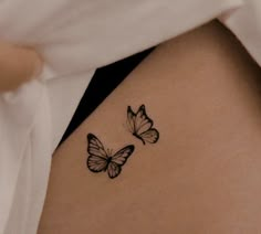 two butterflies on the back of a woman's stomach