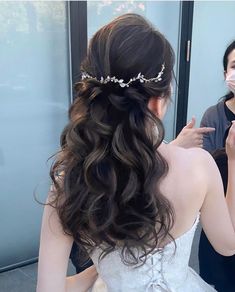 a woman in a wedding dress is looking at her reflection in the mirror while brushing her teeth