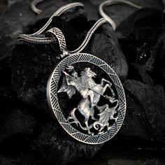 "The Handmade 925K Sterling Saint George and the Dragon pendant by Stone & Stone. Handmade to perfection, these gothic-style pendants offer subtly, texture, and character.  St George and the Dragon pendant is made from 925K Sterling Silver and oxidized for a unique finish. Featuring finely burnished details for a final flourish, there is no such thing as \"off the shelf\".   A beautiful blend of classic presence and texture, with modern-day elegance and sophistication, this Stone & Stone handmad Gothic Sterling Silver Jewelry, Gothic Sterling Silver Jewelry With Polished Finish, Medieval Style Silver Engraved Necklace, St George Dragon Tattoo, Medieval Sterling Silver Necklace In Silver, Gothic Engraved Pendant Necklace, Gothic Sterling Silver Necklace With Oxidized Finish, Medieval Sterling Silver Jewelry In Antique Silver, Medieval Sterling Silver Pendant Jewelry