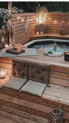 an outdoor hot tub with lights on the side and wooden steps leading up to it