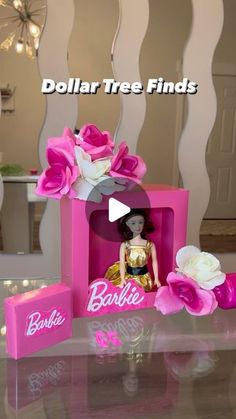 barbie doll in pink box with flowers on table