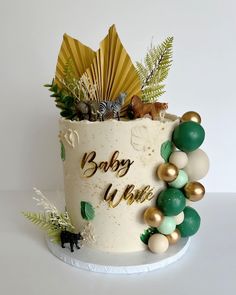 there is a cake decorated with gold, green and white decorations on the top of it