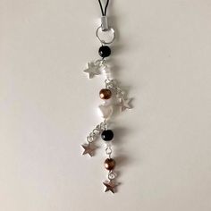 a necklace with stars and beads hanging from it's side on a white surface