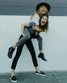 two women in hats and jeans are hugging each other