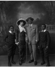 an old black and white photo of three men in suits with canes standing next to each other