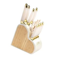 a set of knives in a wooden holder with gold trimmings on the handles