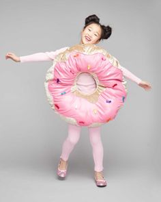 a woman in pink is holding a giant donut