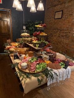 a table filled with lots of food on top of a wooden floor