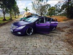 a purple car parked on top of a brick road