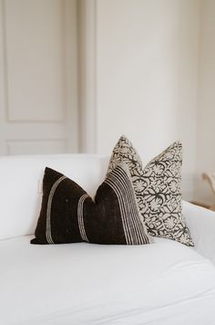 two black and white pillows on a white couch