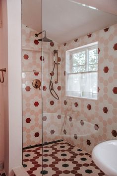 the bathroom is decorated in pink and brown hexagonal tiles, along with a white sink