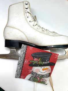 a pair of ice skates sitting on top of a white table next to a card