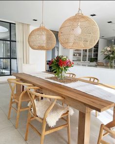 a dining room table with chairs and hanging lights