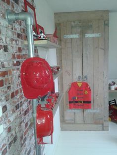 a red fireman's life jacket on display in a room with brick walls