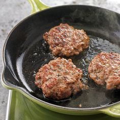 three hamburger patties cooking in a frying pan