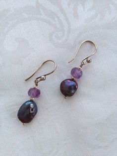 "Faceted amethysts and freshwater coin pearl earrings set in hand made sterling silver. The amethysts are a dark rich purple and have natural inclusions and the coin pearls are nice and metallic. Hand made sterling silver hooks and spacer beads. Height: 33mm/1.29\" Amethyst & pearl drop sterling silver earrings, faceted amethyst and metallic coin pearls, handmade drop earrings" Handmade Purple Dangle Pearl Earrings, Purple Teardrop Pearl Drop Jewelry, Purple Pearl Drop Jewelry, Silver Sterling Silver Pearl Earrings With Natural Stones, Purple Pearl Drop Dangle Earrings, Silver Pearl Earrings With Natural Stones In Sterling Silver, Purple Dangle Pearl Drop Earrings, Purple Amethyst Jewelry With Pearl Drop, Purple Round Pearl Earrings For Gift