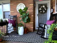 the front porch is decorated with black and white decor