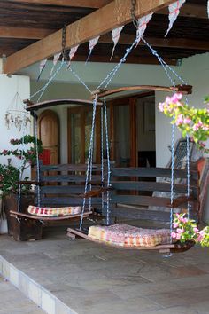 a porch with swings and potted plants