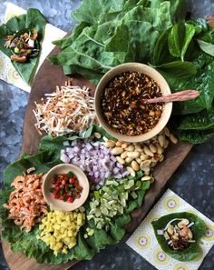 several different types of vegetables on a cutting board with chopsticks and seasonings