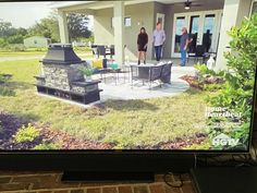 a flat screen tv sitting on top of a wooden table in front of a house