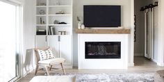 a living room with a fireplace and white furniture