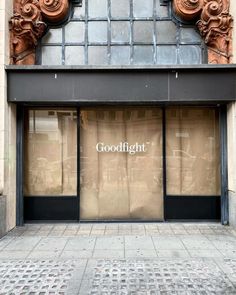 the front entrance to a clothing store with an ornately carved doorway and window display