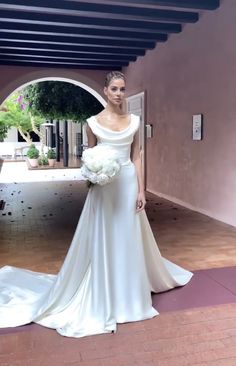 a woman in a white wedding dress posing for the camera