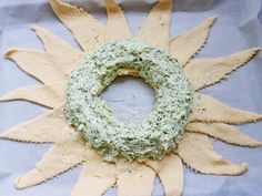 a wreath made out of dough on top of a sheet of paper with the shape of a sun