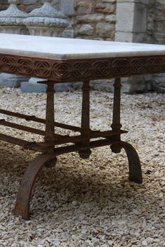 an old table is sitting on some gravel