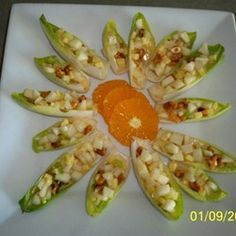 a white plate topped with green bell peppers covered in toppings and an orange sauce