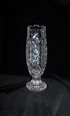 a clear glass vase sitting on top of a black cloth