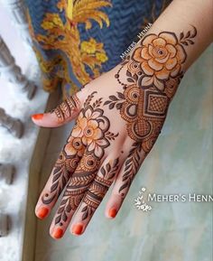 a woman's hand with henna tattoos on it