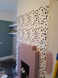 a room that has been painted with black and white polka dots on the walls, including a fireplace