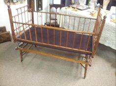 a wooden crib sitting on top of a carpeted floor next to a table