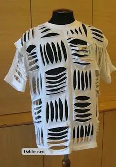 a white t - shirt with black strips and holes on the front, sitting on a mannequin