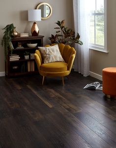 a living room filled with furniture and a mirror on top of a wooden floor next to a window