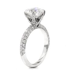 a white gold ring with an oval cut diamond and pave set diamonds on the sides