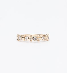 a gold ring with three small diamonds on the front and side, set against a white background