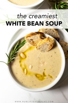 two bowls filled with white bean soup on top of a marble counter next to bread