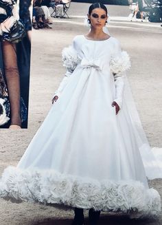 a woman in a long white dress on the runway