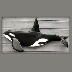 a black and white orca whale hanging on the side of a building