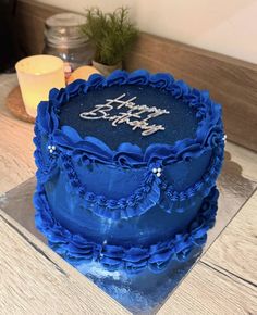 a blue birthday cake sitting on top of a table