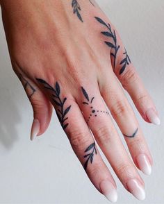 a woman's hand with tattoos on it and an arrow tattoo on the middle finger