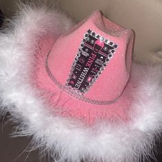 a pink hat with some white feathers around it