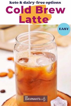 a glass filled with cold drink sitting on top of a wooden table